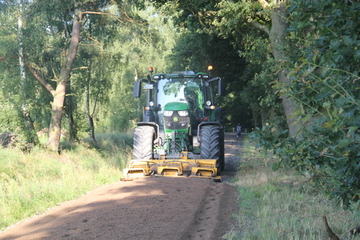 Foto mit Schlepper bei der Pflege eines Waldweges