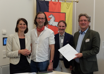 Ministerin Miriam Staudte mit Projektverantwortlichen bei der Übergabe des Förderbescheids