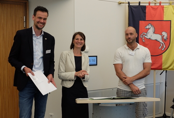 Ministerin Miriam Staudte mit Projektverantwortlichen bei der Übergabe des Förderbescheids