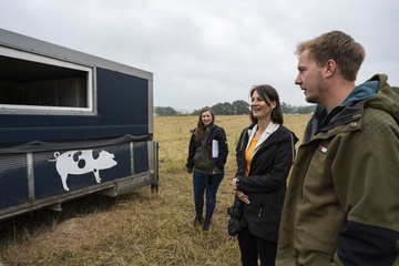 Ministerin Miriam Staudte mit Landwirt vor einem mobilen Schweinestall