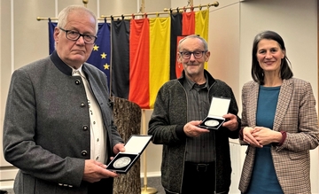 Forstministerin Miriam Staudte übergibt Herrn Hansmann und Herrn Bonse die Forstmedaille.