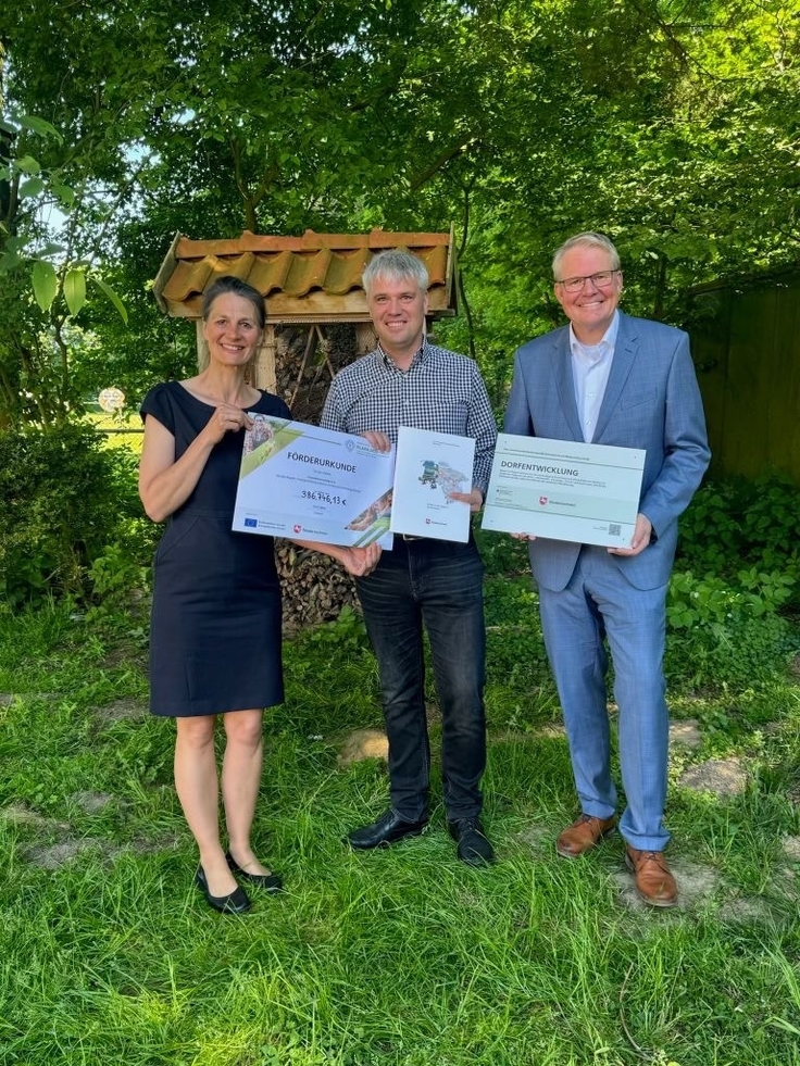 Foto: Ministerin Miriam Staudte übergibt einen Förderbescheid an Stefan Schockmann. Auch auf dem Foto: Nikolaus Jansen (Landesbeauftragter ArL Weser-Ems)