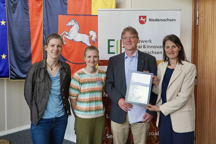 Landwirtschaftsministerin Miriam Staudte (rechts) übergibt den Bescheid für die EIP-Förderung an das Projekt „Lichtfalle Praxis“.