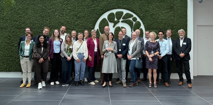 Gruppenbild vor einer grün bewachsenen Wand