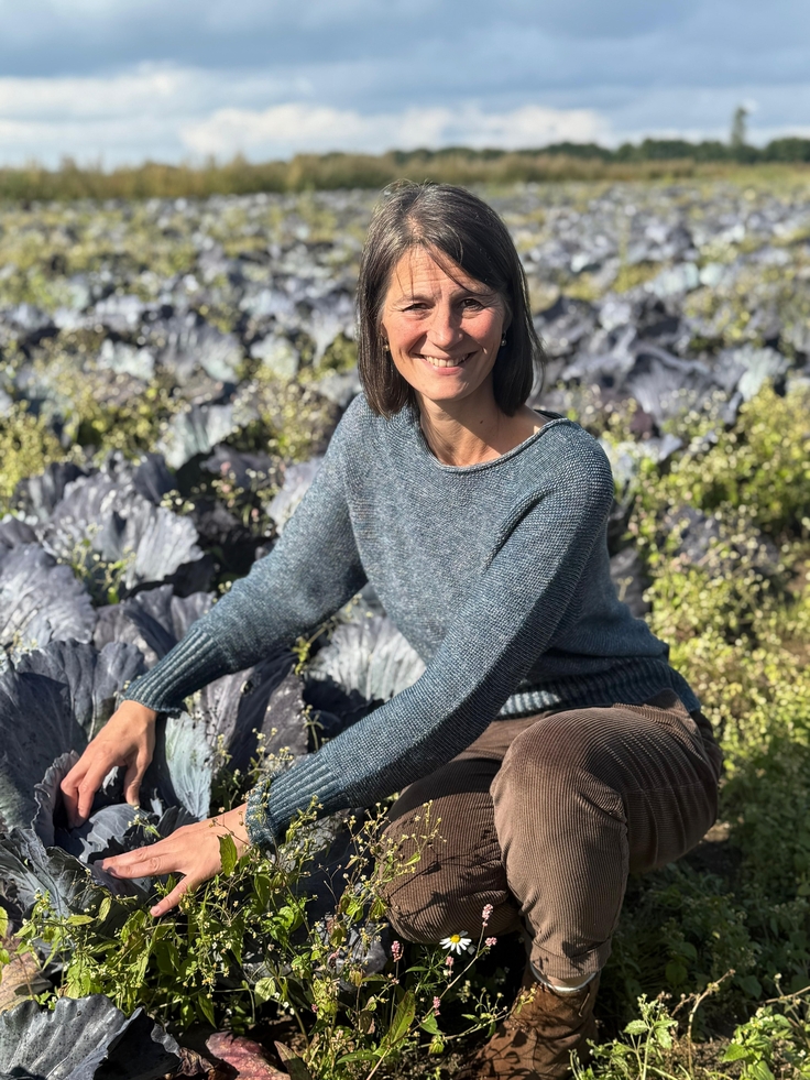 Ministerin Miriam Staudte hockt in einem Rotkohlacker