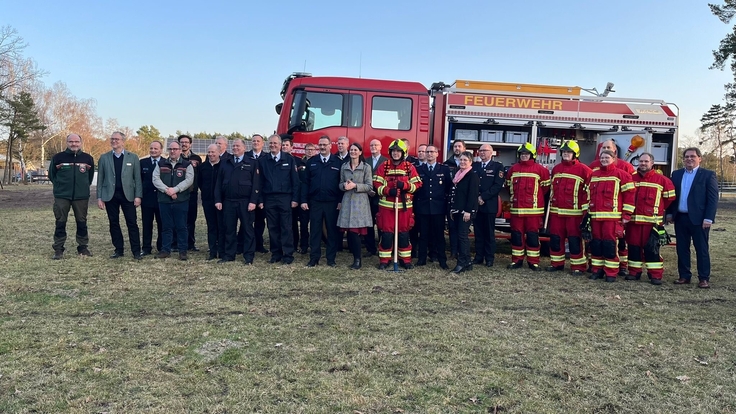 Ministerin Miriam Staudte (15 v. l.) übergibt gemeinsam mit dem Präsidenten des LFV-NDS Olaf Kapke (14 v. l.) die Löschrucksäcke und Waldbrandwerkzeuge