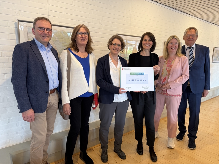 Ministerin Miriam Staudte (4. v. l.) übergibt an die ev.-luth. Kirchengemeinde St. Martin Estebrügge eine Förderurkunde