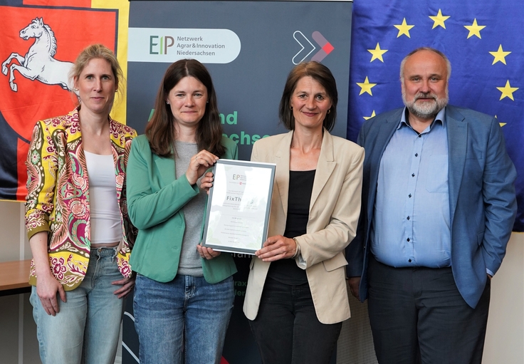 Landwirtschaftsministerin Miriam Staudte (mittig) übergibt den Bescheid für die EIP-Förderung an das Projekt „FixThePig“.