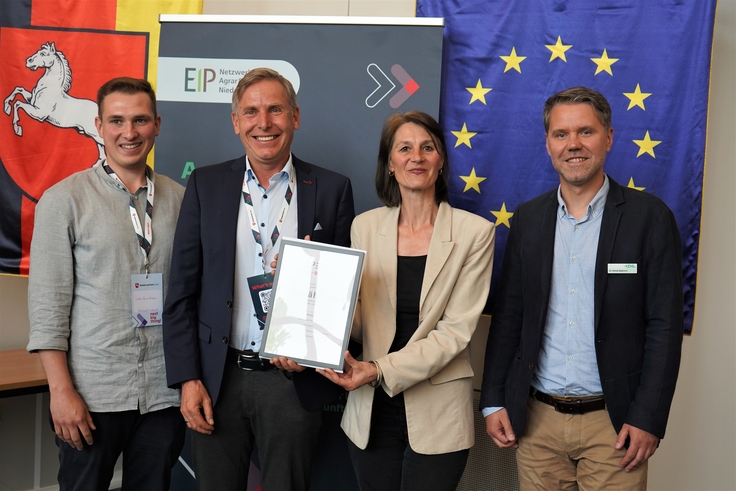 Landwirtschaftsministerin Miriam Staudte (mittig) übergibt den Bescheid für die EIP-Förderung an das Projekt „Grashähnchen“.