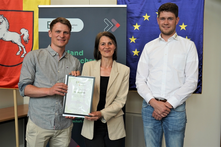 Landwirtschaftsministerin Miriam Staudte (mittig) übergibt den Bescheid für die EIP-Förderung an das Projekt „HempFill“.