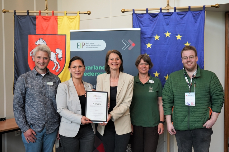 Landwirtschaftsministerin Miriam Staudte (mittig) übergibt den Bescheid für die EIP-Förderung an das Projekt „NarLab“.