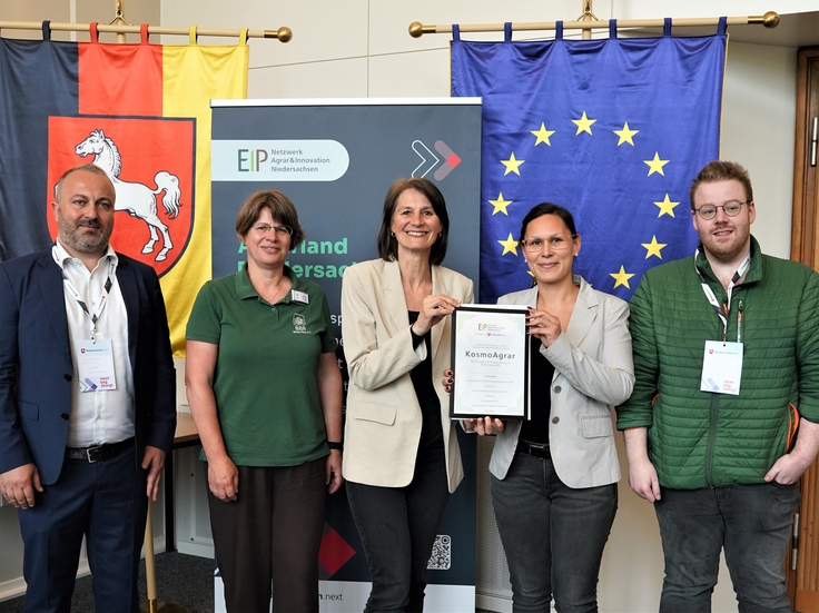Landwirtschaftsministerin Miriam Staudte (mittig) übergibt den Bescheid für die EIP-Förderung an das Projekt „KosmoAgrar“.