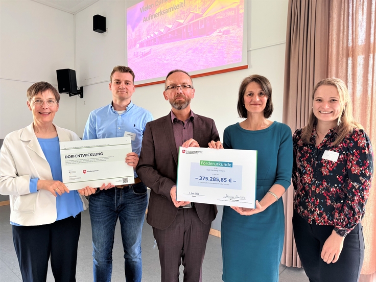 Ministerin Miriam Staudte (4. v. l.) übergibt eine Förderurkunde Erneuerung des Funktionsgebäudes des Freibades in Scharzfeld.