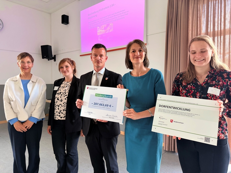 Ministerin Miriam Staudte (4. v. l.) übergibt eine Förderurkunde zur Sanierung eines Gehweges mit Treppenanlage in der Gemeinde Walkenried.