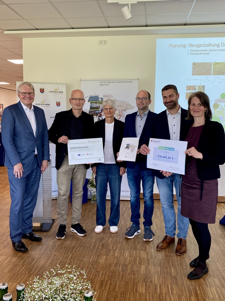 Ministerin Miriam Staudte übergibt mit Nikolaus Jansen (Landesbeauftragter für regionale Landesentwicklung) den Förderbescheid für das Projekt "Neugestaltung Dorfplatz Amdorf", LK Leer