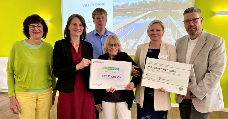 Ministerin Staudte (2. v. l.) übergibt einen Förderbescheid für die Errichtung eines Sanitärgebäudes für den Wasserpark Wennigsen