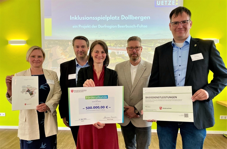 Ministerin Staudte (mitte) übergibt einen Förderbescheid für einen Inklusionsspielplatz in Dollbergen