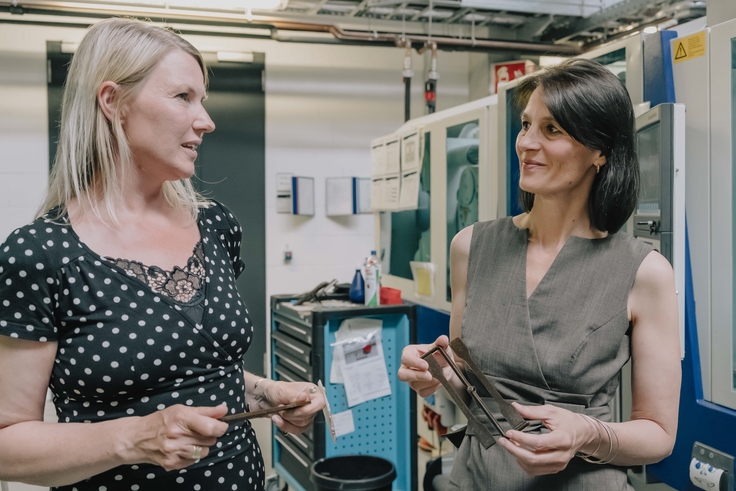 Ministerin Miriam Staudte mit einer blonden Frau in einer Produktionshalle