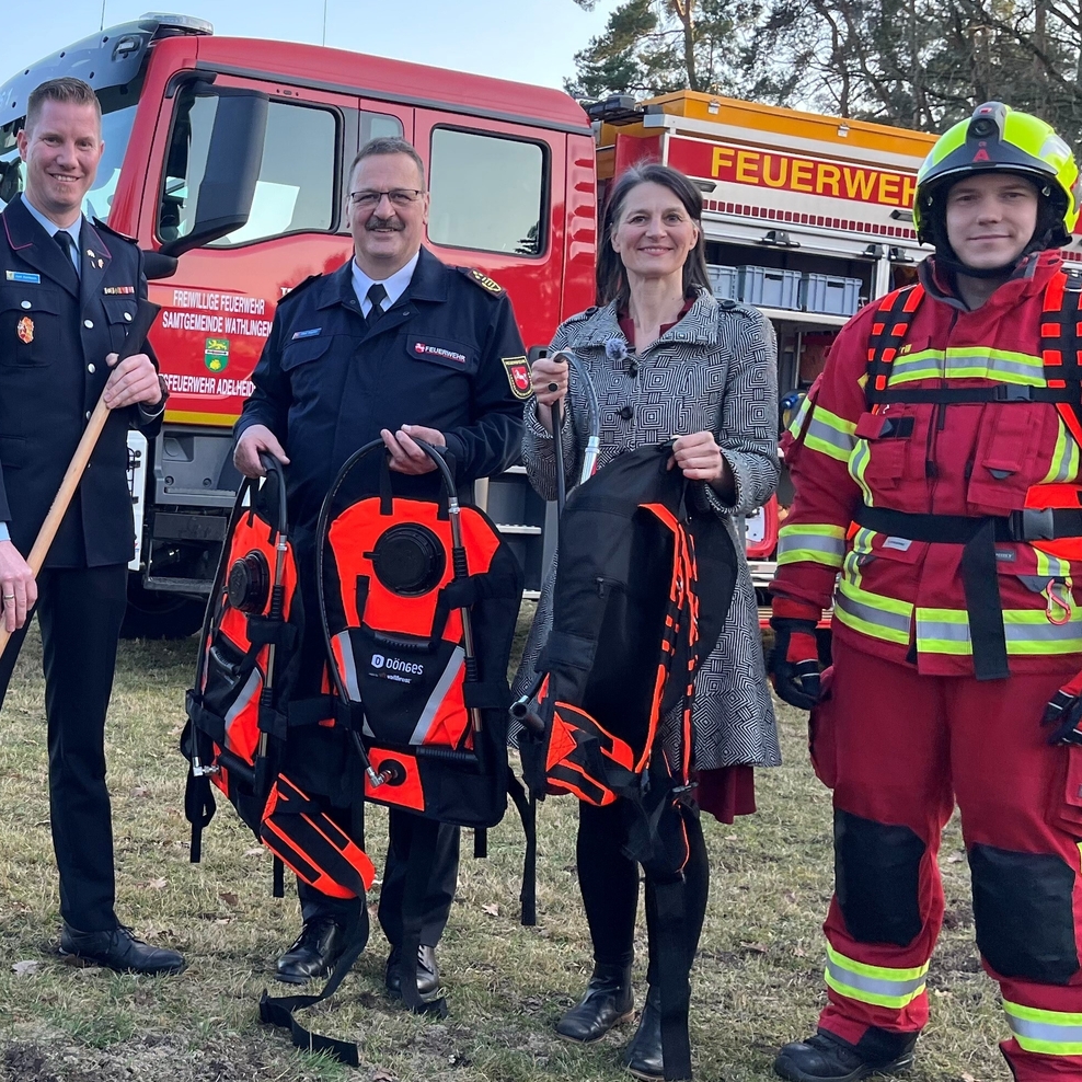 Ein Foto zeigt Ministerin Staudte bei der Übergabe der Waldbrand-Löschrucksäcke an die Kreisfeuerewehr aus dem Landkreis Lüchow Dannenberg