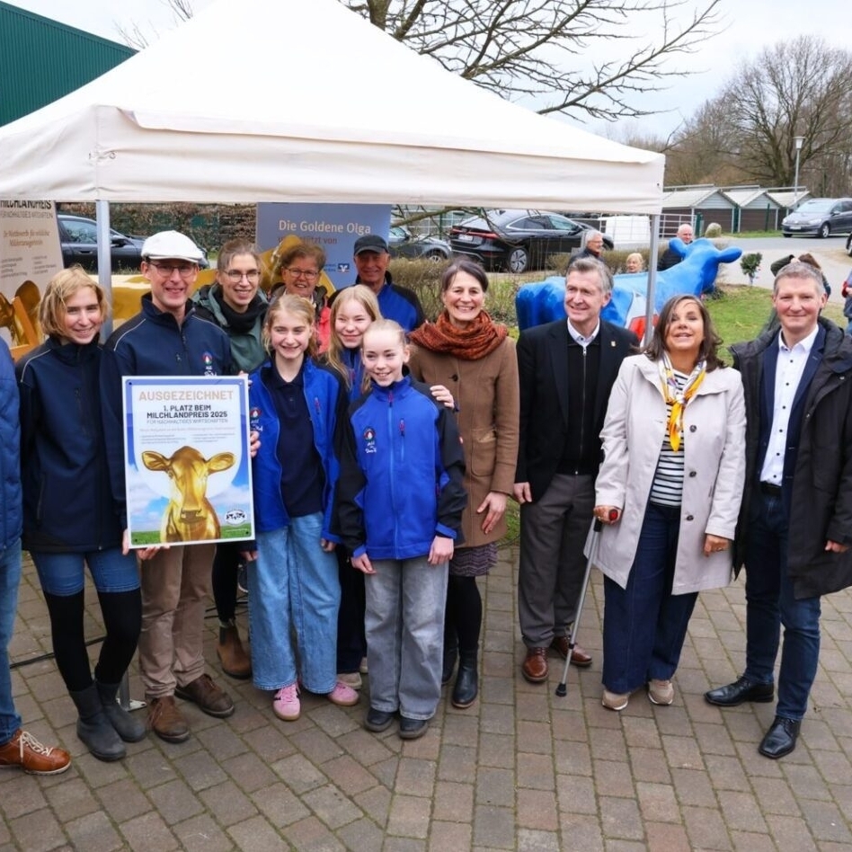 Ein Foto zeigt Ministerin Miriam Staudte bei der Aufstellung der "Goldenen Olga" gemeinsam mit Familie Diers und weiteren Ehrengästen