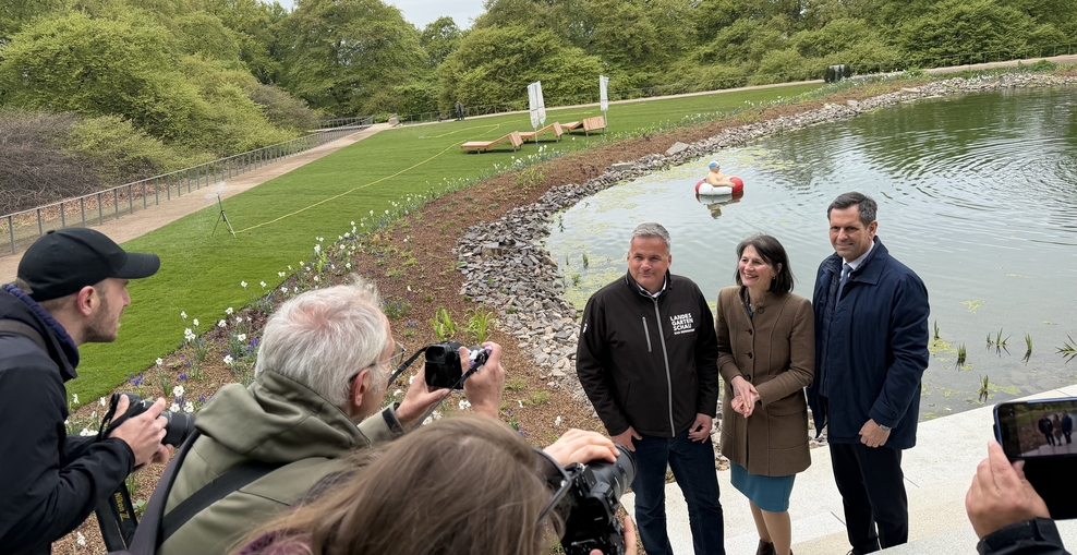 Landwirtschaftsminsiterin Miriam Staudte steht mit Ministerpräsident Olaf Lies und Stadxtdirektor Mike Schmidt in Bad Nenndorf vor einem anlegeten See auf dem Gelände der Landesgartenschau 2026