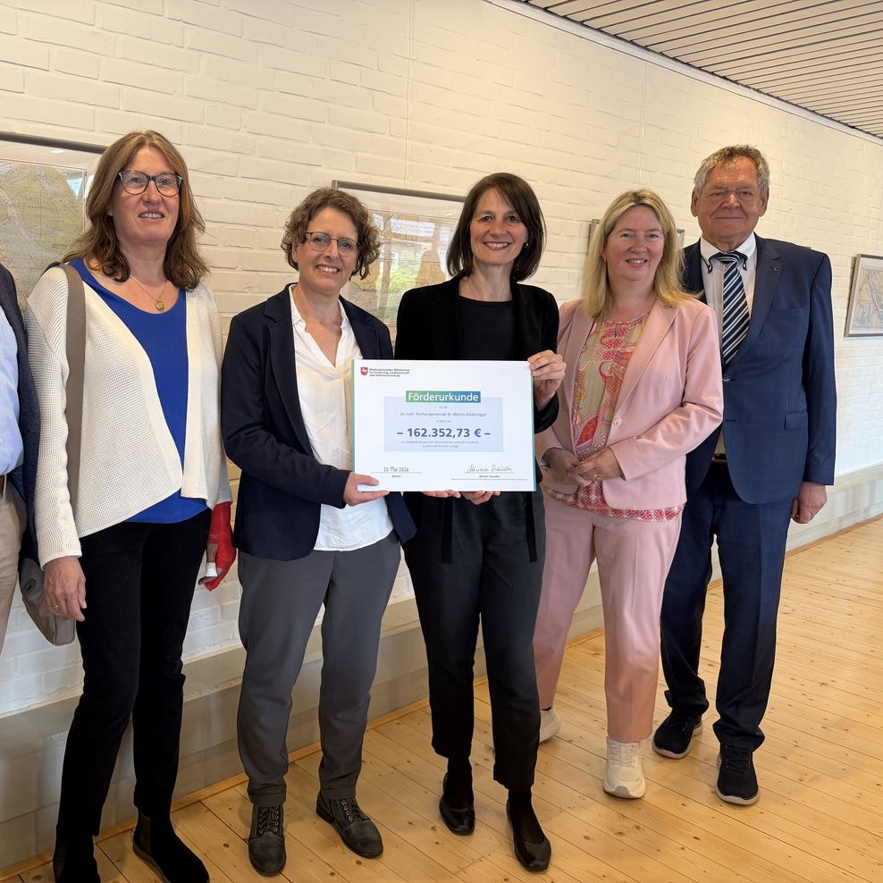 Ministerin Miriam Staudte (4. v. l.) übergibt an die ev.-luth. Kirchengemeinde St. Martin Estebrügge eine Förderurkunde