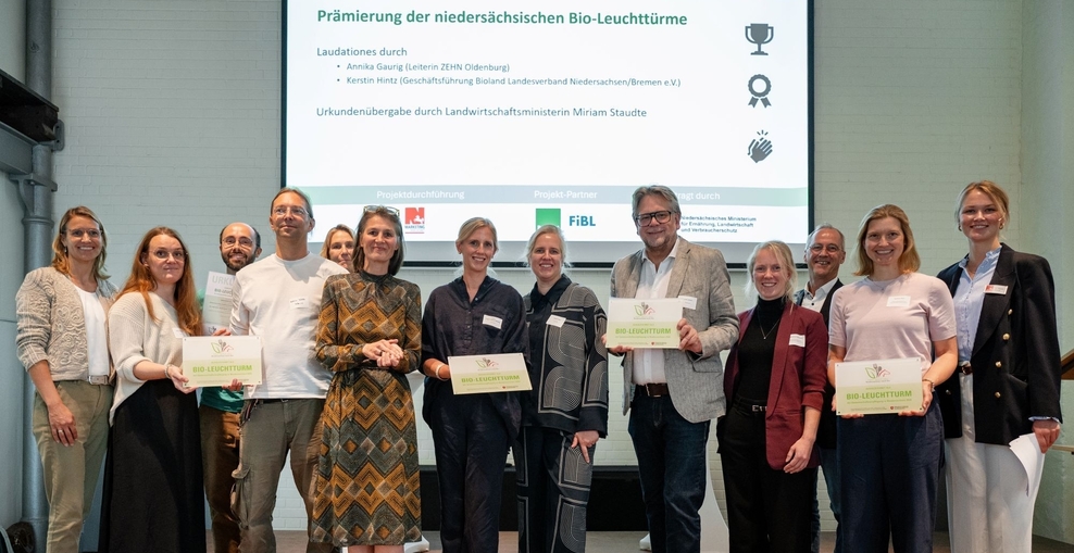 Gruppenbild in einem Raum vor einer Präsentation